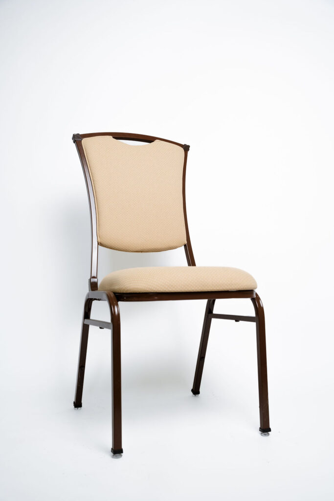 Sofisticação e Robustez para Grandes Eventos A Cadeira Safira CF da Tomberlin foi projetada para atender às altas exigências do mercado de hotéis e eventos. Com um design elegante, ela garante não apenas o conforto visual e físico dos convidados, mas também um excelente retorno sobre o investimento devido à sua durabilidade superior ao tempo. Estrutura de Alta Performance Fabricada com estrutura reforçada em aço carbono , a cadeira recebe um exclusivo tratamento nanocerâmico e acabamento em pintura eletrostática a pó. Esses processos garantem máxima proteção contra o desgaste diário. Para projetos que exigem maior leveza no manuseio, a estrutura padrão em aço carbono pode ser substituída por alumínio , o que reduz o peso da peça em média 2 kg. Conforto Prolongado Pensando no bem-estar durante palestras, casamentos e convenções, o assento e o encosto são desenvolvidos com espuma injetada e revestidos em tecido 100% poliéster. Armazenamento Inteligente e Diferenciais Tomberlin Empilhamento Seguro: Sistema inteligente que garante um grande número de cadeiras empilhadas com segurança e praticidade , permitindo pilhas de até 10 unidades para este modelo. Protetor Lateral: Todos os modelos possuem protetores em plástico injetado nas laterais , desenhados especificamente para evitar danos no empilhamento. Sapatas em Policarbonato: O policarbonato é mais resistente a atritos e impactos , garantindo mais durabilidade à peça.