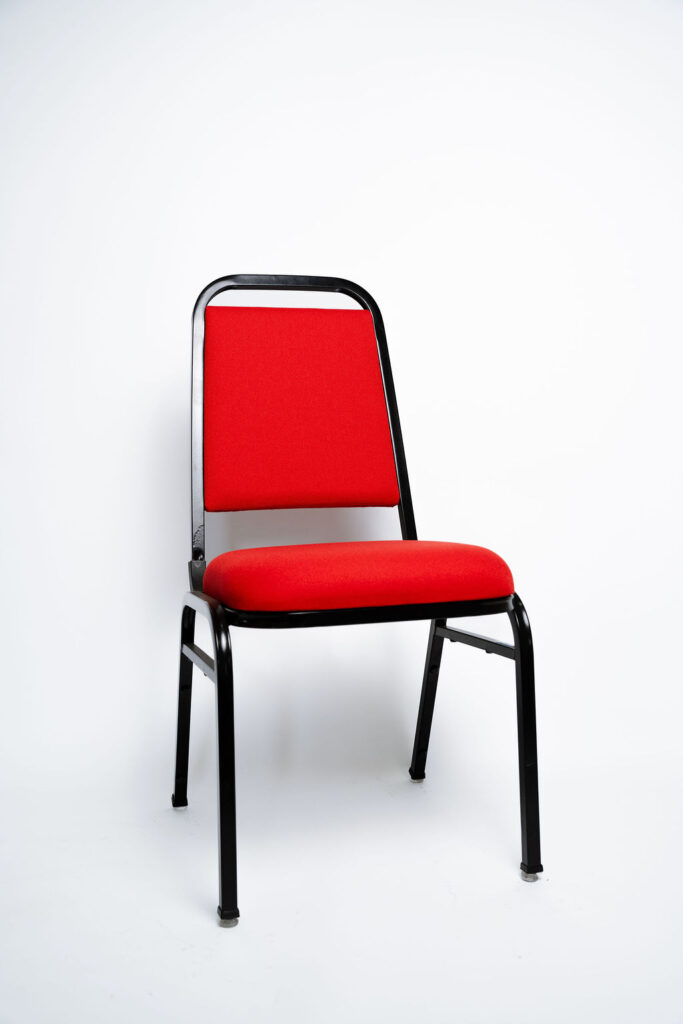 A Cadeira Standart CS da Tomberlin oferece o melhor custo-benefício para eventos e hotelaria. Estrutura em aço carbono, empilhamento seguro e sapatas em policarbonato.Descrição do ProdutoResistência e Praticidade para o seu NegócioA Cadeira Standart CS é a escolha inteligente para quem busca um equipamento robusto e de longa vida útil para salões de eventos e hotéis. Seu design clássico e funcional foi rigorosamente pensado para otimizar a operação diária do seu espaço.Estrutura de Alta Performance Como padrão, a cadeira é fabricada com estrutura reforçada em aço carbono, recebendo um exclusivo tratamento nanocerâmico. O acabamento é feito com pintura eletrostática a pó, oferecendo uma camada extra de proteção contra o desgaste. Caso haja necessidade, a estrutura pode ser fabricada em alumínio (sob consulta), o que reduz o peso da peça em cerca de 2 kg.Ergonomia e Conforto Pensando em eventos de longa duração, tanto o assento quanto o encosto são desenvolvidos com espuma injetada e revestidos em tecido 100% poliéster.