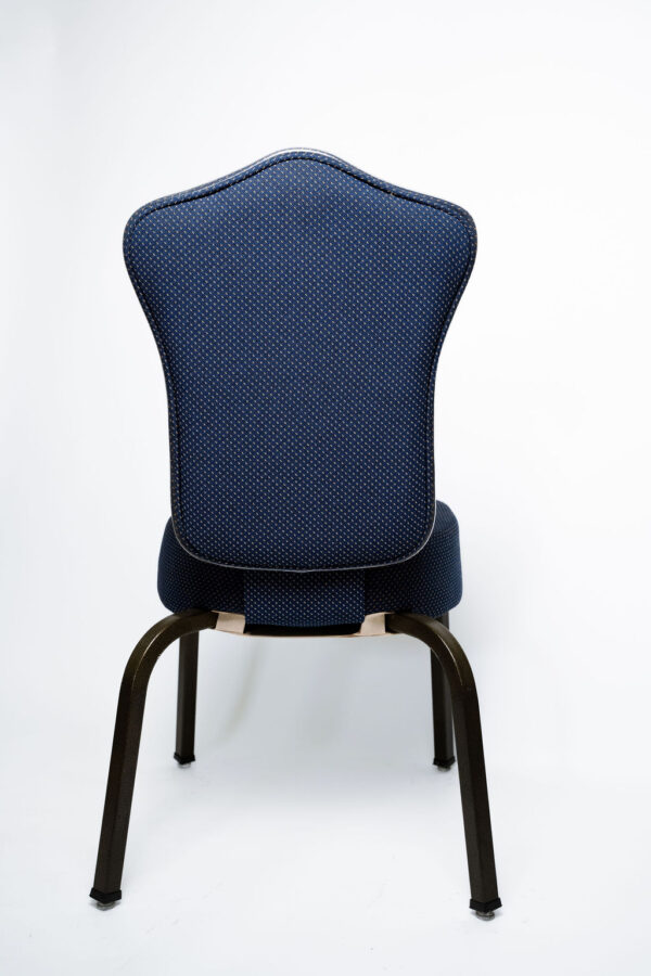 Elegância e Máxima Resistência A Cadeira Agatha CAT da Tomberlin foi desenvolvida para trazer um visual clássico e de alto padrão aos espaços corporativos e de hospitalidade. Ideal para salões de eventos e hotéis , ela entrega o equilíbrio perfeito entre uma estética refinada e a robustez necessária para o uso intenso diário. Estrutura de Alta Performance Fabricada como padrão com estrutura reforçada em aço carbono , a Agatha recebe um exclusivo tratamento nanocerâmico e acabamento em pintura eletrostática a pó , garantindo a máxima proteção contra desgastes. Para projetos que demandam peças mais leves, a estrutura pode ser encomendada em alumínio, o que reduz o peso total em média 2 kg. É importante ressaltar que cadeiras em alumínio não aceitam o acessório Braço Universitário. Conforto Prolongado Para garantir o conforto dos seus convidados do início ao fim do evento, tanto o assento quanto o encosto são desenvolvidos com espuma injetada e revestimento em tecido 100% poliéster. Armazenamento Inteligente e Diferenciais Tomberlin Empilhamento Seguro: Sistema estrutural inteligente projetado para garantir que as cadeiras sejam empilhadas com total segurança e praticidade na sua operação. Este modelo permite pilhas de até 5 cadeiras. Protetor Lateral: Todos os modelos de cadeiras contam com protetores em plástico injetado nas laterais, criados especificamente para evitar atritos e danos ao empilhamento. Sapatas em Policarbonato: O policarbonato é mais resistente a atritos e impactos, garantindo uma vida útil prolongada ao móvel e protegendo o piso do seu estabelecimento.